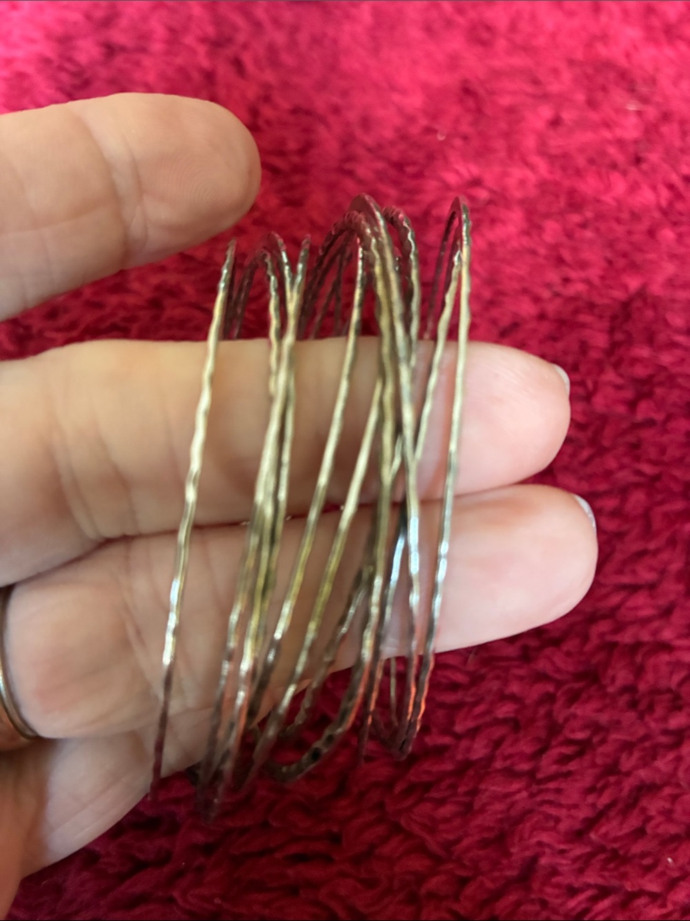 Set of 11 silvertone bangles, attached